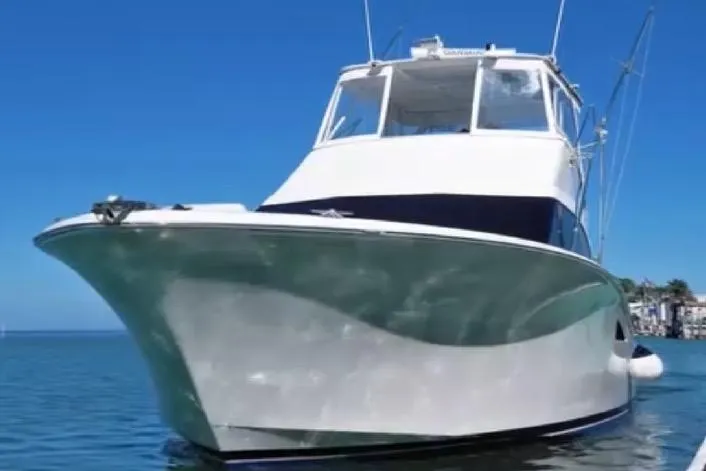 Slide: The Image of 2008 Luhrs 36 Convertible boat on calm water under clear blue sky. - 1