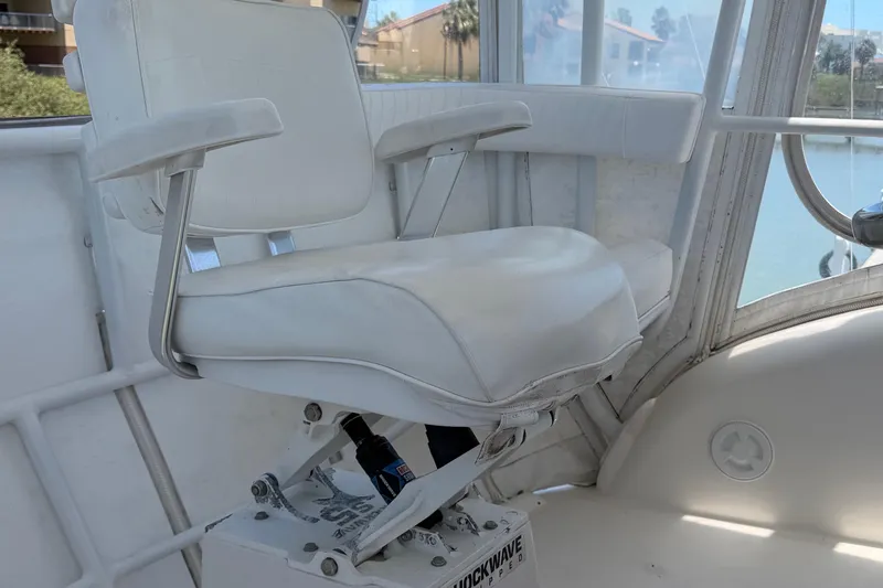 Slide: The Image of Captain's chair on 2008 Luhrs 35 Convertible boat, featuring white upholstery and sturdy design. - 11