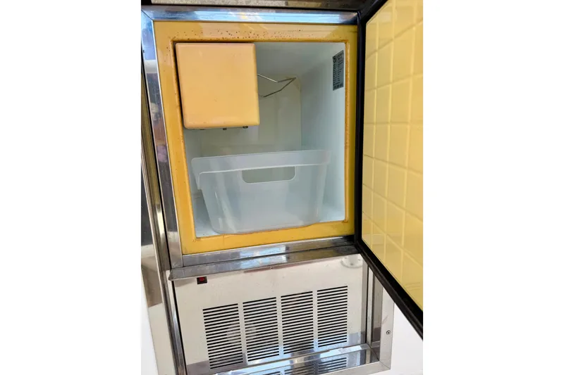 Slide: The Image of Ice maker inside a 2008 Luhrs 35 Convertible boat, featuring a yellow interior. - 18