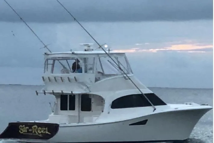 Slide: The Image of 2008 Luhrs 36 Convertible boat on calm water at sunset. - 2