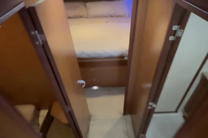 Slide: The Image of Interior view of 2008 Luhrs 36 Convertible yacht cabin with bed and wooden doors. - 7