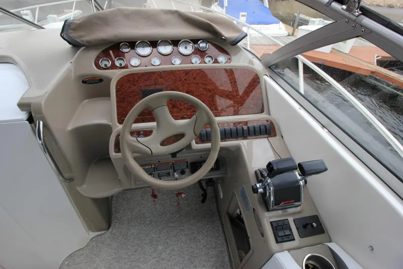 Slide: The Image of 2001 Bayliner 3055 Ciera boat dashboard with steering wheel and control panel. - 13