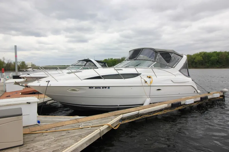 Slide: The Image of 2001 Bayliner 3055 Ciera docked on a calm lake under cloudy skies. - 2