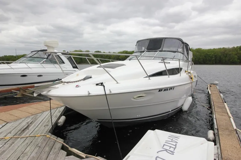 Slide: The Image of 2001 Bayliner 3055 Ciera docked on a cloudy day, featuring sleek white design. - 3