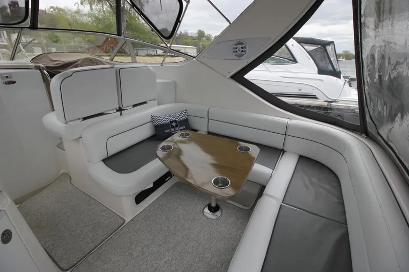 Slide: The Image of 2001 Bayliner 3055 Ciera interior with cushioned seating and wooden table. - 8