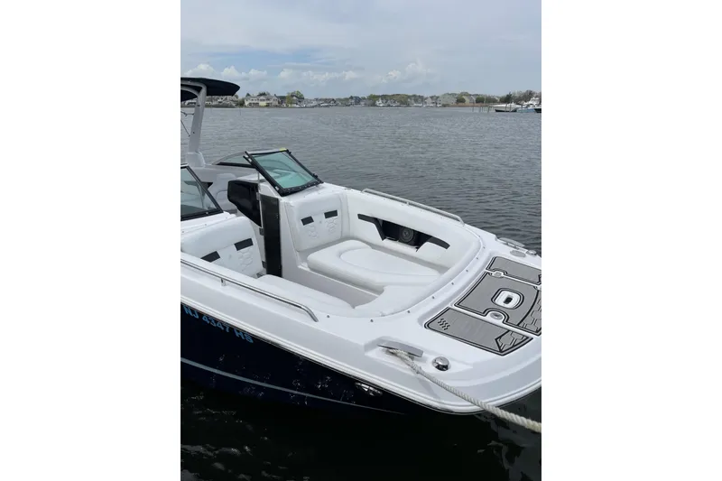 Slide: The Image of 2023 Four Winns HD8 boat with sleek white seating, docked on calm waters. - 4