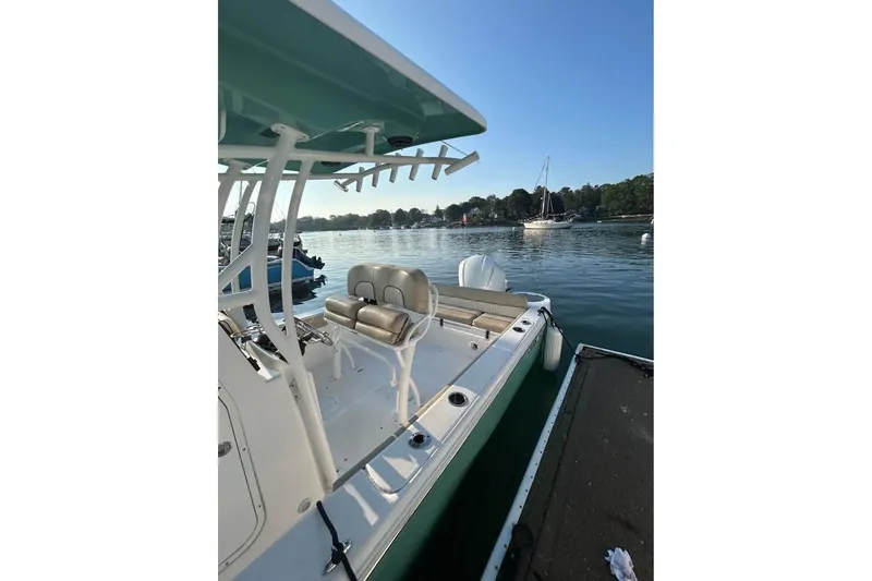 Slide: The Image of 2018 Sea Fox 249 Avenger boat docked on calm water, featuring sleek design and seating. - 5