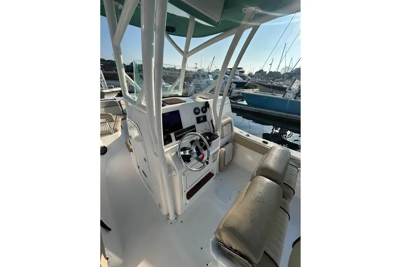 Slide: The Image of 2018 Sea Fox 249 Avenger boat interior with helm, seating, and marina view. - 6