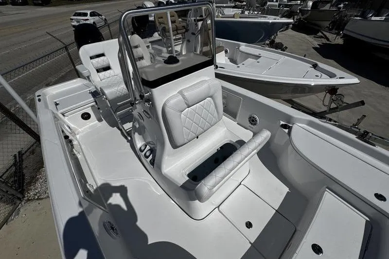 Slide: The Image of 2026 Blazer Bay 2200 boat with white seating and console, docked outdoors. - 11