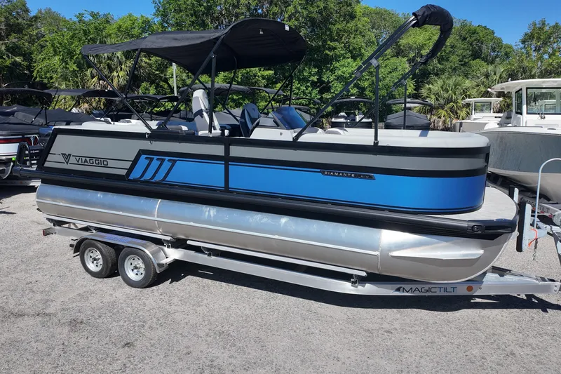The Image of 2026 Viaggio Diamante U 22 pontoon boat on trailer, featuring sleek blue and silver design. - 0