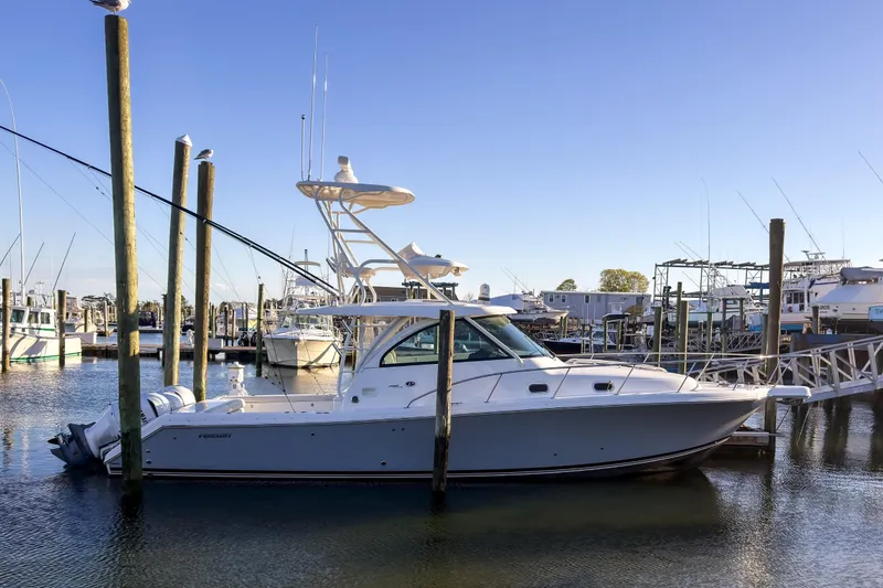 The Image of 2021 Pursuit OS 385 Offshore boat docked in a marina under clear blue skies. - 0