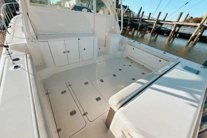 Slide: The Image of 2021 Pursuit OS 385 Offshore boat deck with seating and storage, docked by the water. - 10