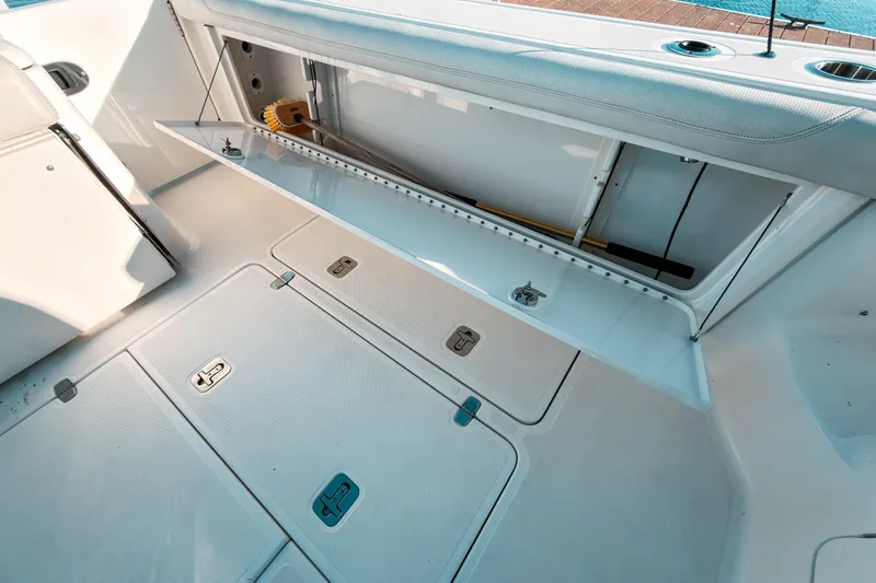 Slide: The Image of 2021 Pursuit OS 385 Offshore boat storage compartment with open hatch and clean deck. - 14