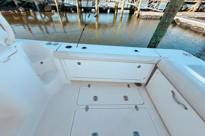 Slide: The Image of 2021 Pursuit OS 385 Offshore boat deck with storage compartments and fishing rod holders. - 16