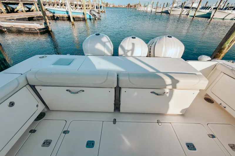 Slide: The Image of 2021 Pursuit OS 385 Offshore boat deck with seating and Yamaha engines at marina. - 19