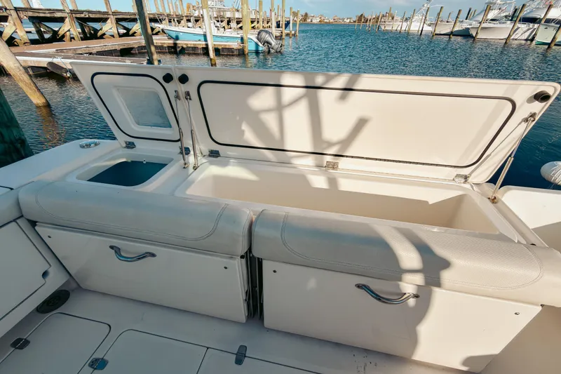 Slide: The Image of 2021 Pursuit OS 385 Offshore boat with open storage compartments at marina. - 21