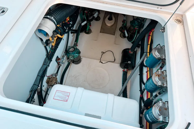Slide: The Image of Engine compartment of a 2021 Pursuit OS 385 Offshore boat, showcasing mechanical components. - 22
