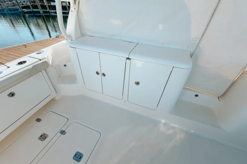 Slide: The Image of 2021 Pursuit OS 385 Offshore boat interior with white storage compartments and seating. - 23