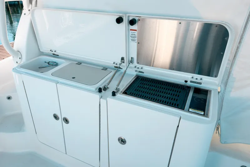 Slide: The Image of Outdoor kitchen on 2021 Pursuit OS 385 Offshore boat with grill and sink. - 24