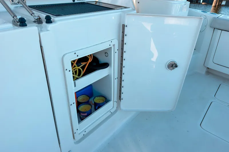 Slide: The Image of Open storage compartment on 2021 Pursuit OS 385 Offshore boat, showing interior contents. - 26