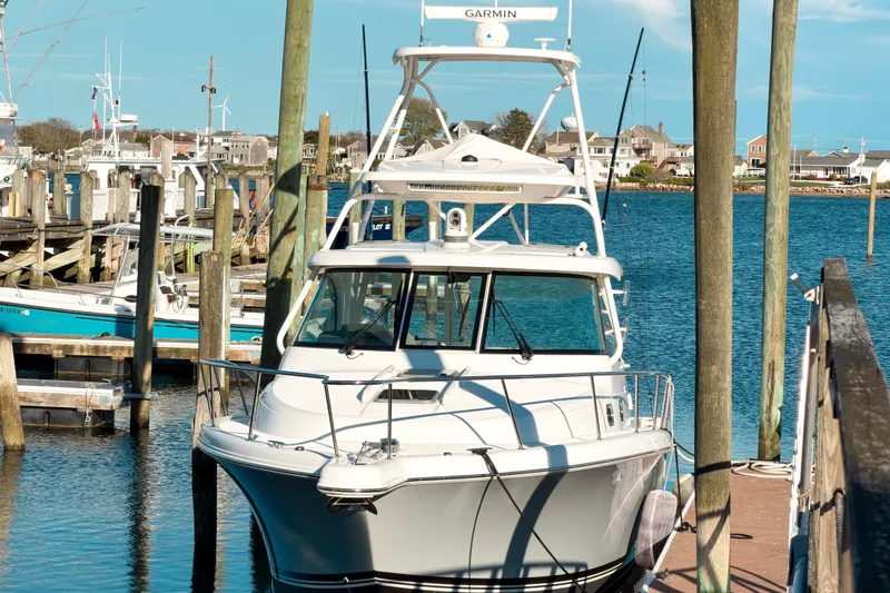 Slide: The Image of 2021 Pursuit OS 385 Offshore boat docked at a marina with clear blue water. - 3