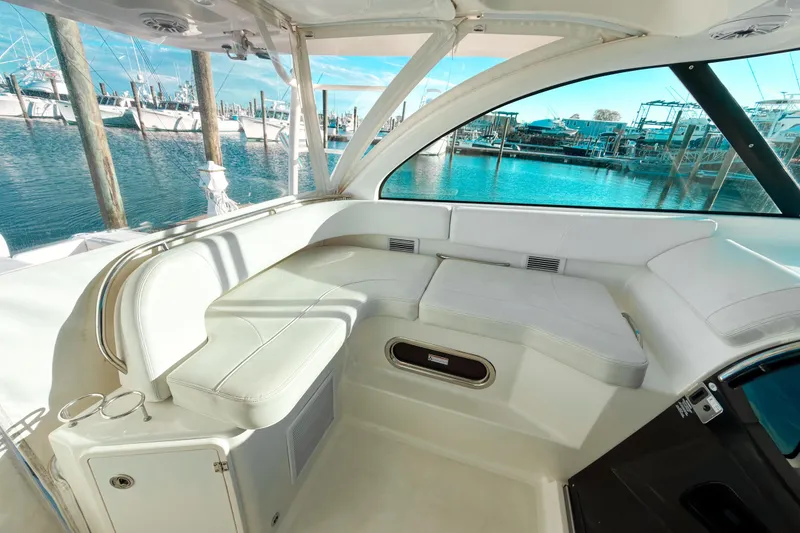 Slide: The Image of 2021 Pursuit OS 385 Offshore boat interior with white seating and marina view. - 30