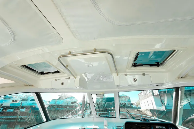 Slide: The Image of Interior view of 2021 Pursuit OS 385 Offshore boat cabin with windows and controls. - 38