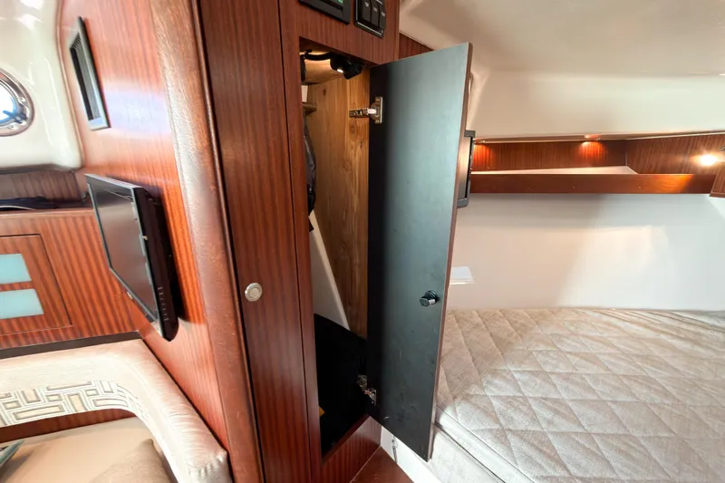 Slide: The Image of 2021 Pursuit OS 385 Offshore cabin interior with wood paneling and cozy sleeping area. - 43