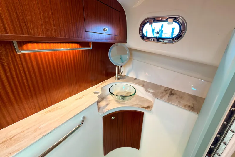 Slide: The Image of Luxurious 2021 Pursuit OS 385 Offshore yacht bathroom with wood cabinetry and glass sink. - 48