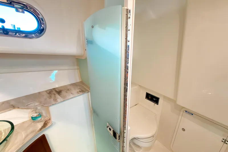 Slide: The Image of 2021 Pursuit OS 385 Offshore yacht bathroom with modern fixtures and frosted glass door. - 49