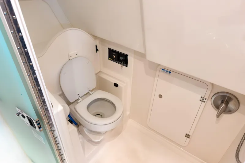 Slide: The Image of 2021 Pursuit OS 385 Offshore boat bathroom with toilet and storage compartment. - 51