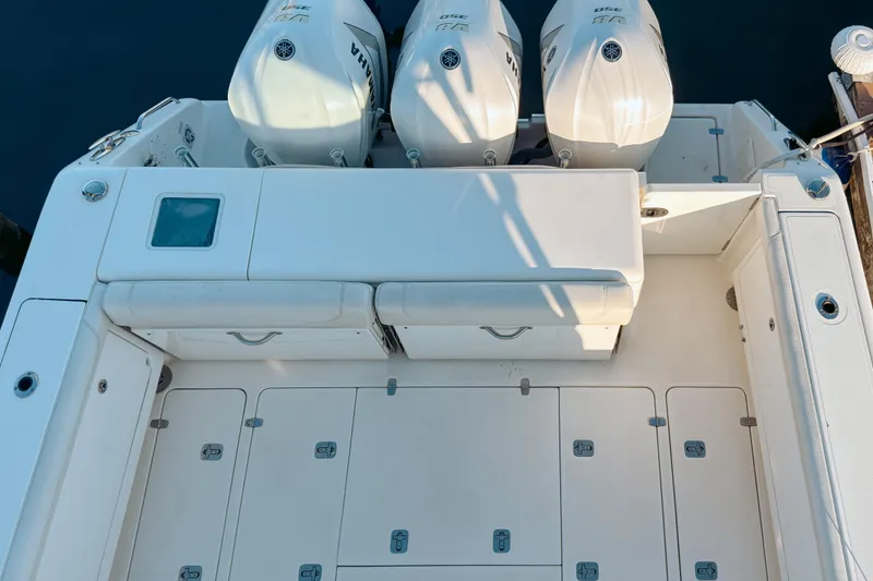 Slide: The Image of 2021 Pursuit OS 385 Offshore boat deck with triple Yamaha engines, spacious seating, and storage compartments. - 68