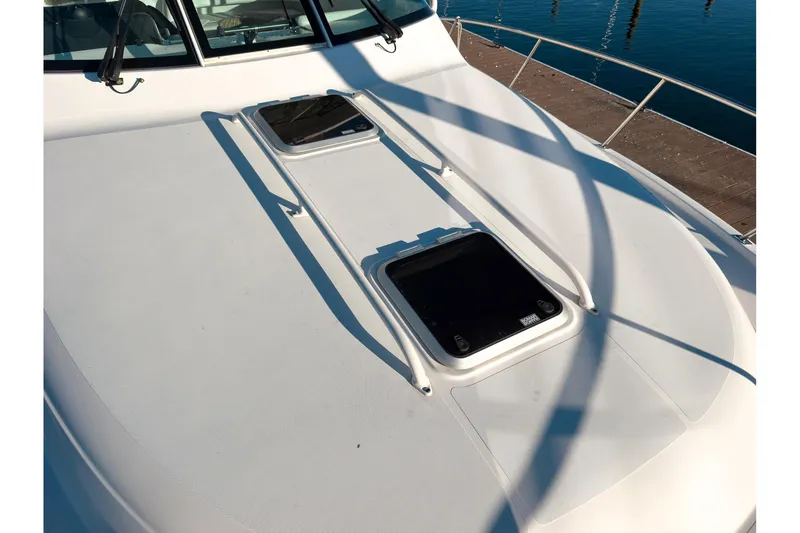Slide: The Image of 2021 Pursuit OS 385 Offshore boat deck with hatches and railing, dockside view. - 73