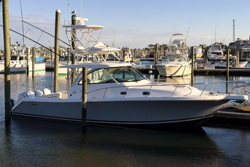 Slide: The Image of 2021 Pursuit OS 385 Offshore boat docked in a marina under clear skies. - 76