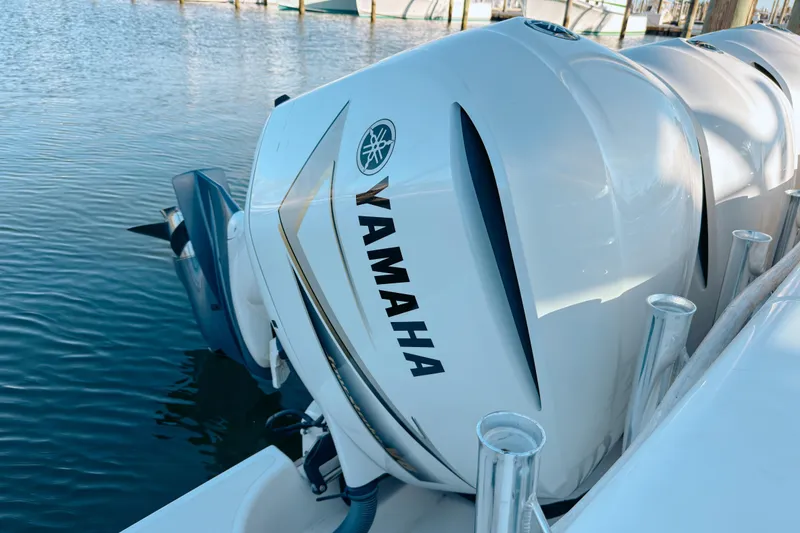 Slide: The Image of Yamaha outboard engines on a 2021 Pursuit OS 385 Offshore boat docked by the water. - 8