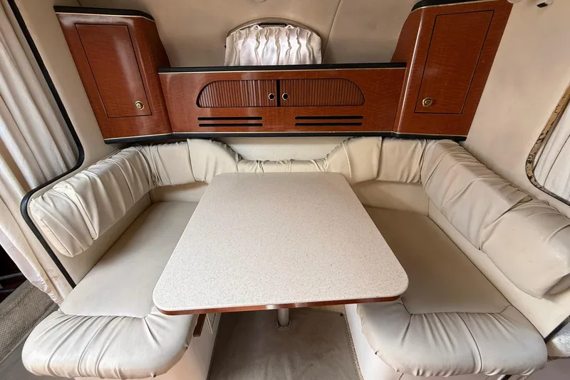 Slide: The Image of Interior of 2001 Sea Ray 280 Sundancer with cushioned seating and wooden cabinetry. - 14