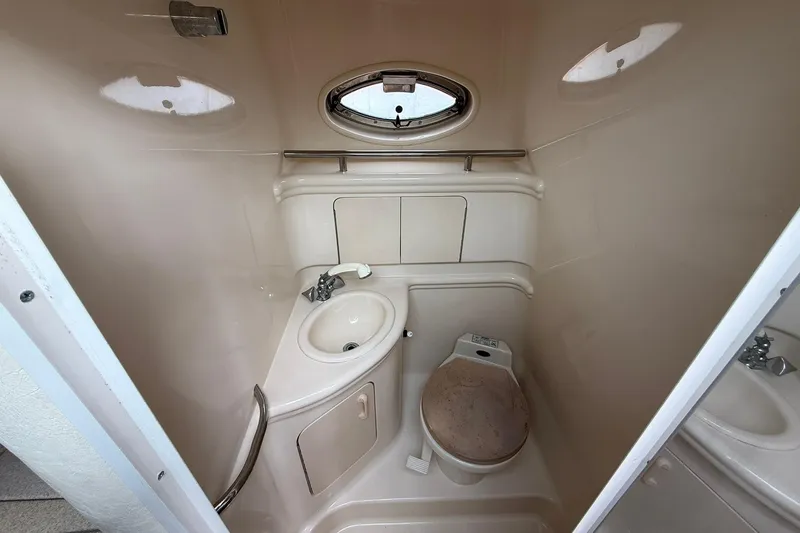 Slide: The Image of Compact bathroom in 2001 Sea Ray 280 Sundancer boat, featuring sink and toilet. - 16