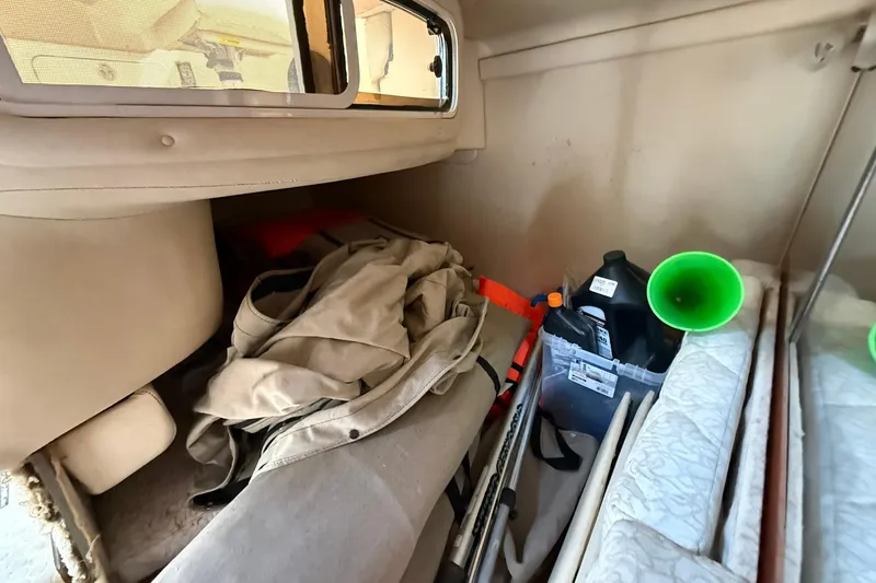 Slide: The Image of Interior storage area of a 2001 Sea Ray 280 Sundancer boat with various items. - 17
