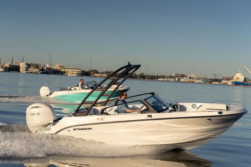 The Image of 2026 Stingray 20 SBX boat cruising on calm water at sunset. - 1
