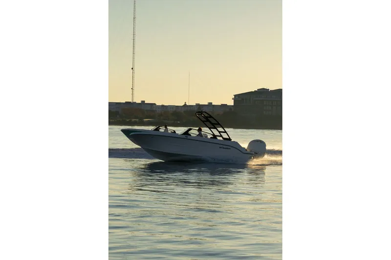Slide: The Image of Stingray 20 SBX 2026 boat cruising at sunset on water. - 14