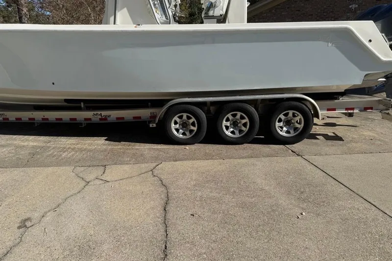 Slide: The Image of 2019 SeaVee 320B boat on a triple-axle trailer, parked on a concrete driveway. - 3