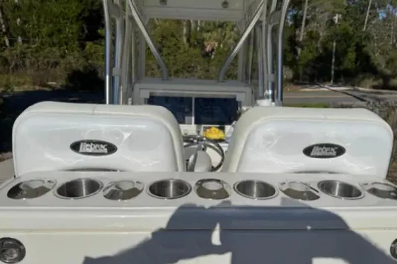 Slide: The Image of 2019 SeaVee 320B boat interior with rod holders and seating, set against a wooded backdrop. - 5