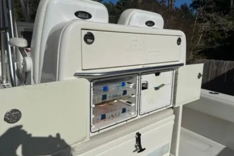Slide: The Image of 2019 SeaVee 320B boat storage compartment with open doors and organized tackle boxes. - 6