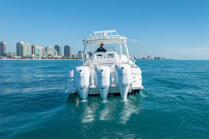 The Image of 2016 Intrepid 375 Center Console boat cruising near city skyline. - 1