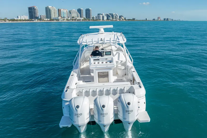 Slide: The Image of 2016 Intrepid 375 Center Console boat cruising on clear blue ocean near city skyline. - 10