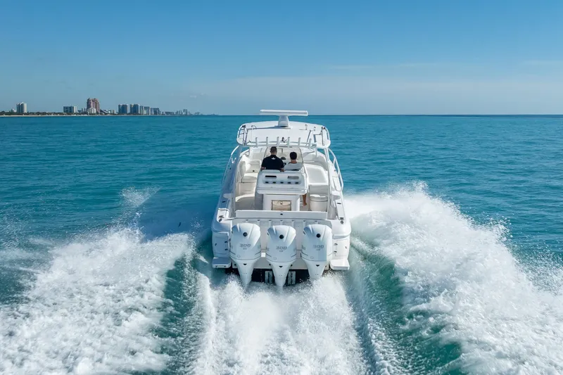 Slide: The Image of Intrepid 375 Center Console 2016 cruising on open water with city skyline in background. - 11