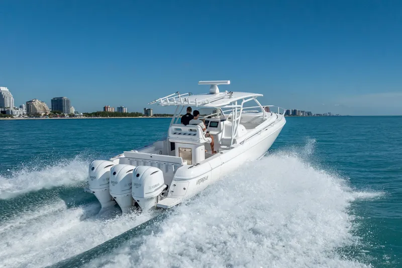 Slide: The Image of 2016 Intrepid 375 Center Console boat cruising on blue ocean near city skyline. - 13