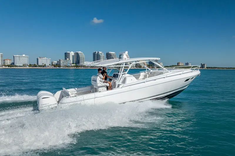Slide: The Image of 2016 Intrepid 375 Center Console cruising on blue ocean near city skyline. - 14