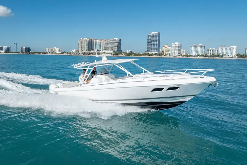 Slide: The Image of 2016 Intrepid 375 Center Console cruising on blue ocean near city skyline. - 16