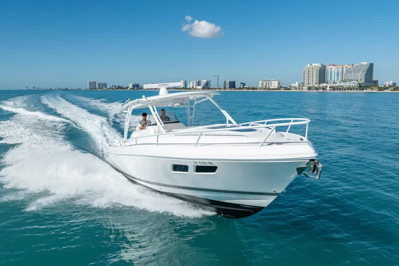 Slide: The Image of 2016 Intrepid 375 Center Console cruising on clear blue waters near a city skyline. - 17